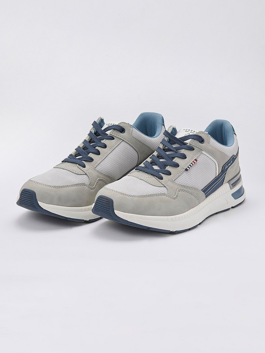 Zapatillas de deporte de hombre en color gris con cordones, confeccionadas en poliuretano y poliéster para estilo, resistencia y comodidad.