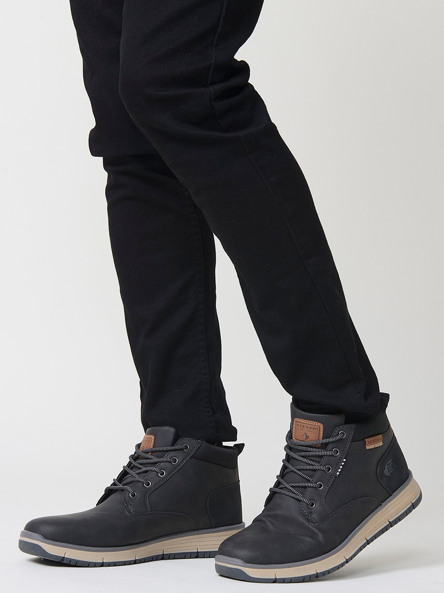 Botín de hombre en color negro con cordones, confeccionado en poliuretano y poliéster. Diseño moderno, resistente y versátil para el día a día.