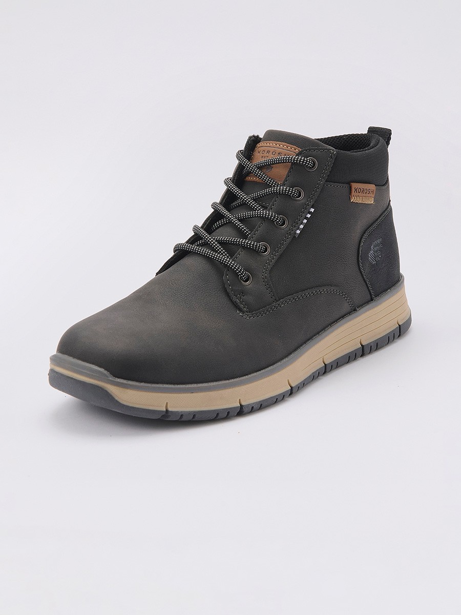 Botín de hombre en color negro con cordones, confeccionado en poliuretano y poliéster. Diseño moderno, resistente y versátil para el día a día.