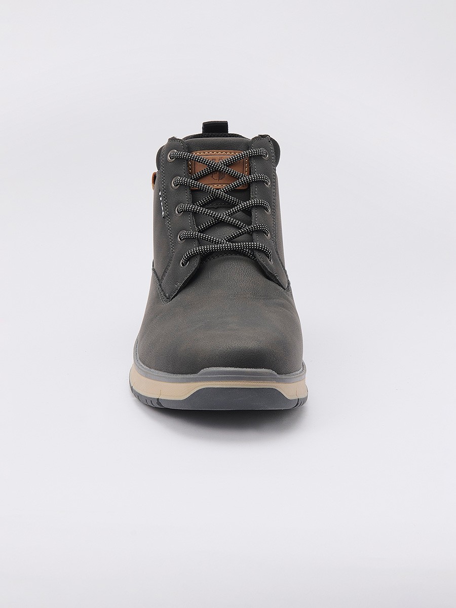 Botín de hombre en color negro con cordones, confeccionado en poliuretano y poliéster. Diseño moderno, resistente y versátil para el día a día.