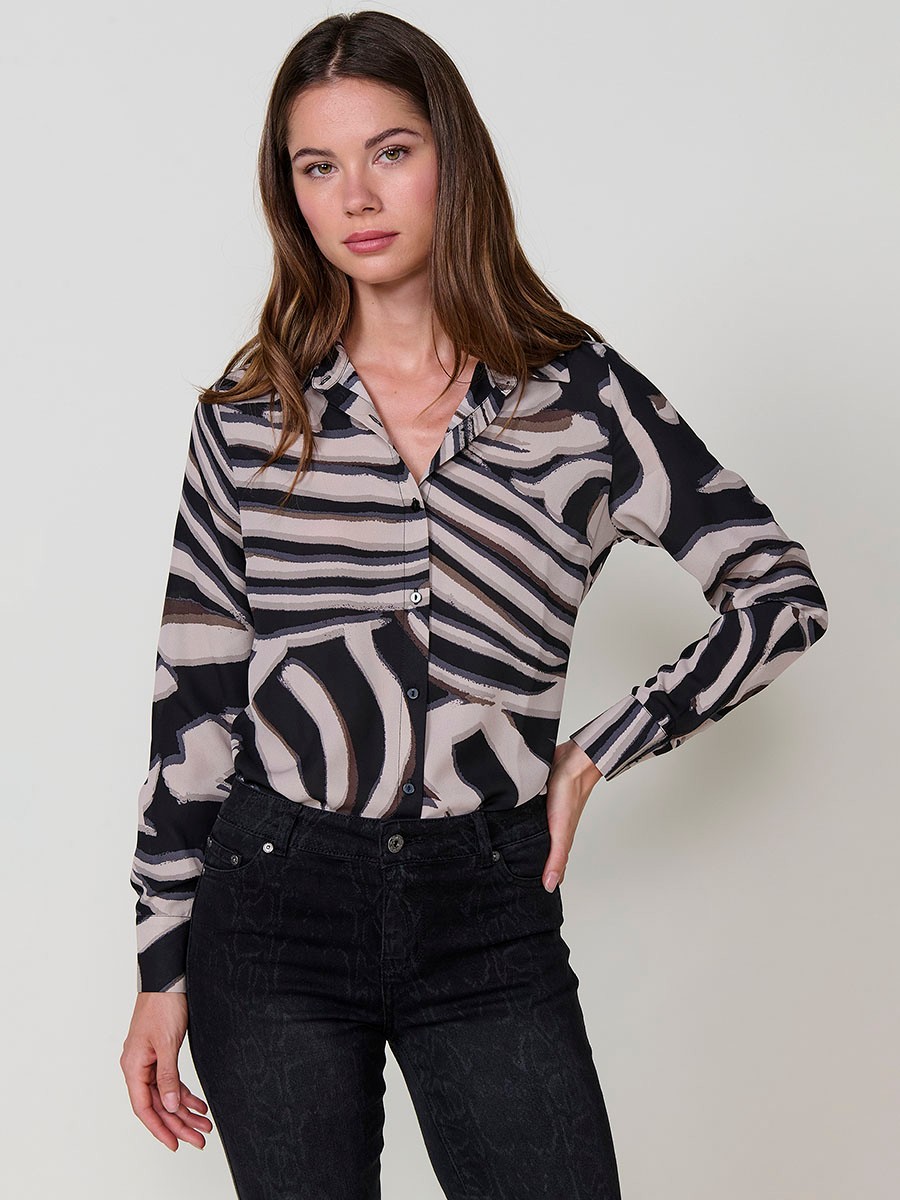 Camisa de mujer en tejido satinado con estampado animal, cuello camisero, manga larga con puño abotonado y cierre de botones.