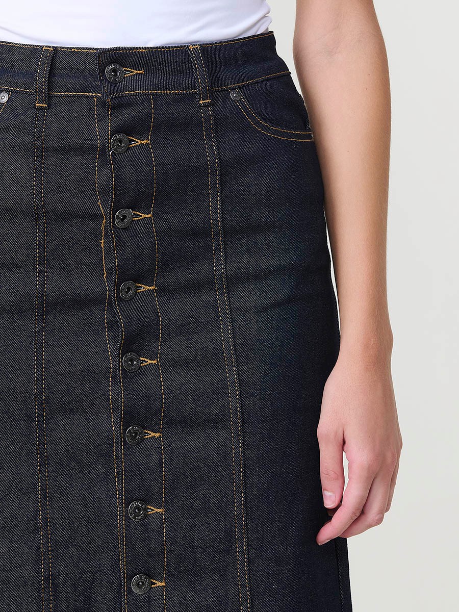 Falda midi de mujer en tejido vaquero elástico azul muy oscuro, con bolsillos y cierre con botones metálicos.
