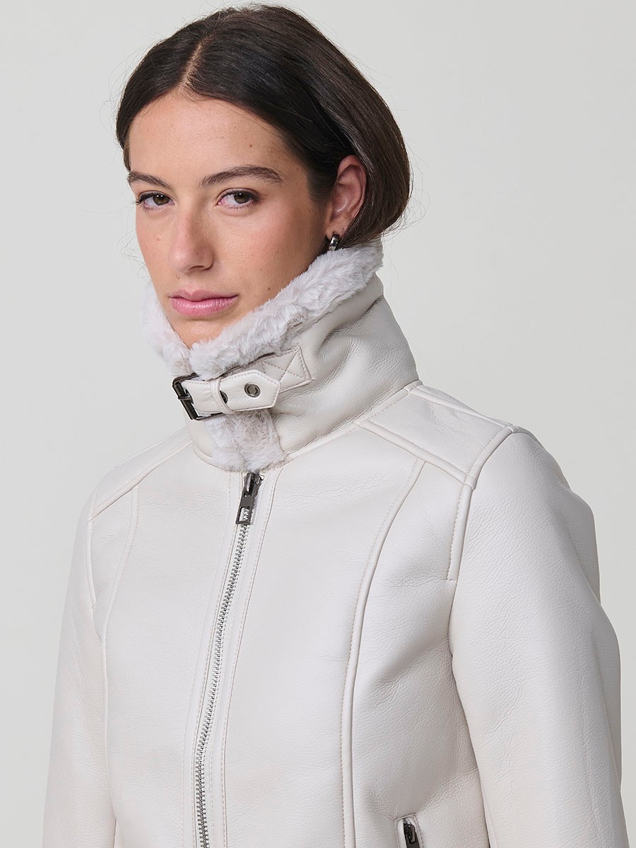 Women’s white double-faced faux leather jacket with faux fur lining, metallic zip pockets and buckle neck detail.