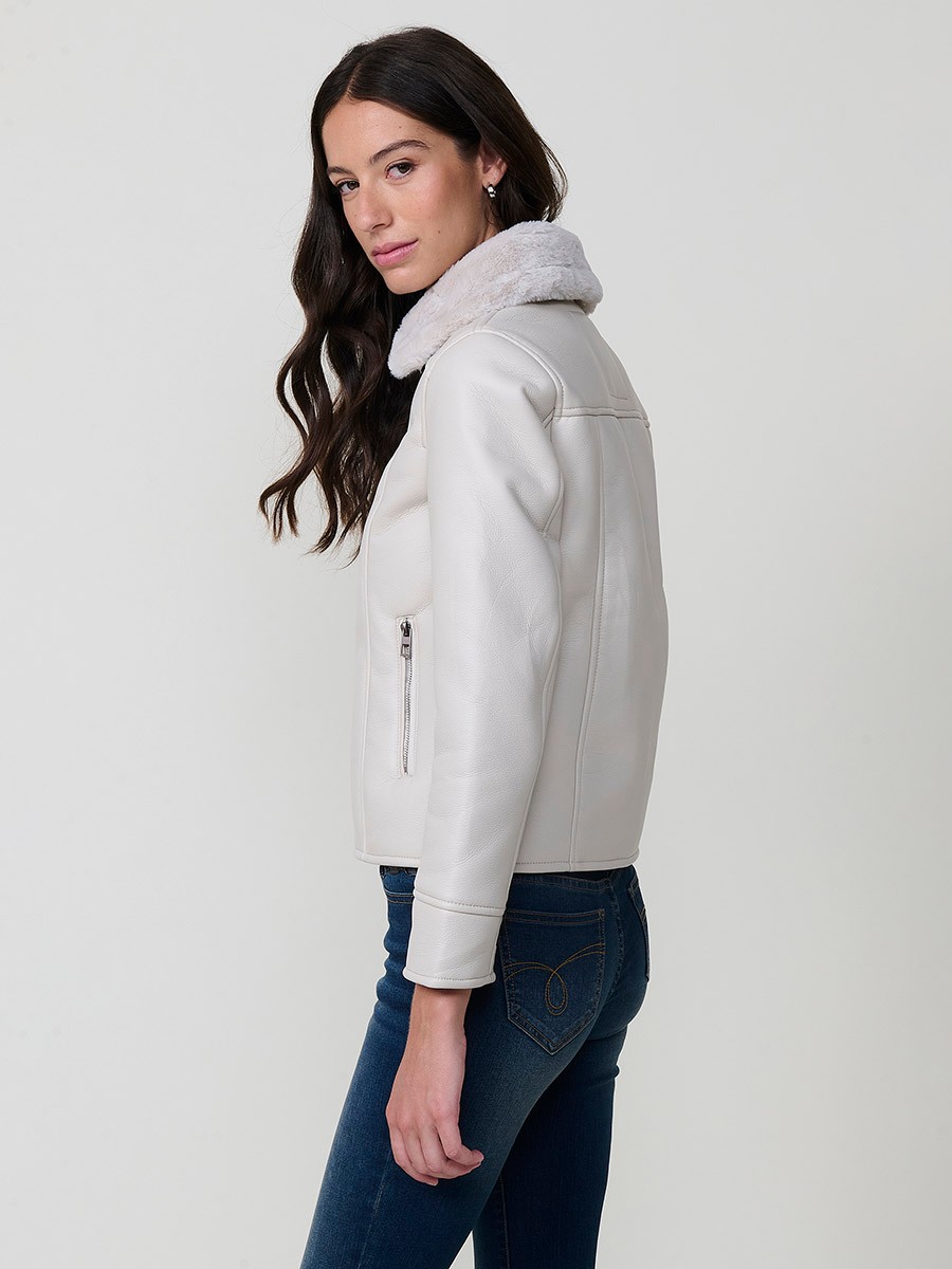 Women’s white double-faced faux leather jacket with faux fur lining, metallic zip pockets and buckle neck detail.