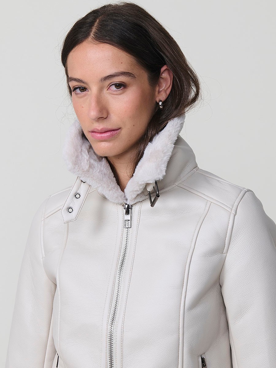 Women’s white double-faced faux leather jacket with faux fur lining, metallic zip pockets and buckle neck detail.