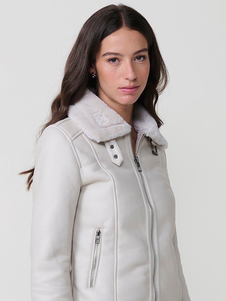 Women’s white double-faced faux leather jacket with faux fur lining, metallic zip pockets and buckle neck detail.