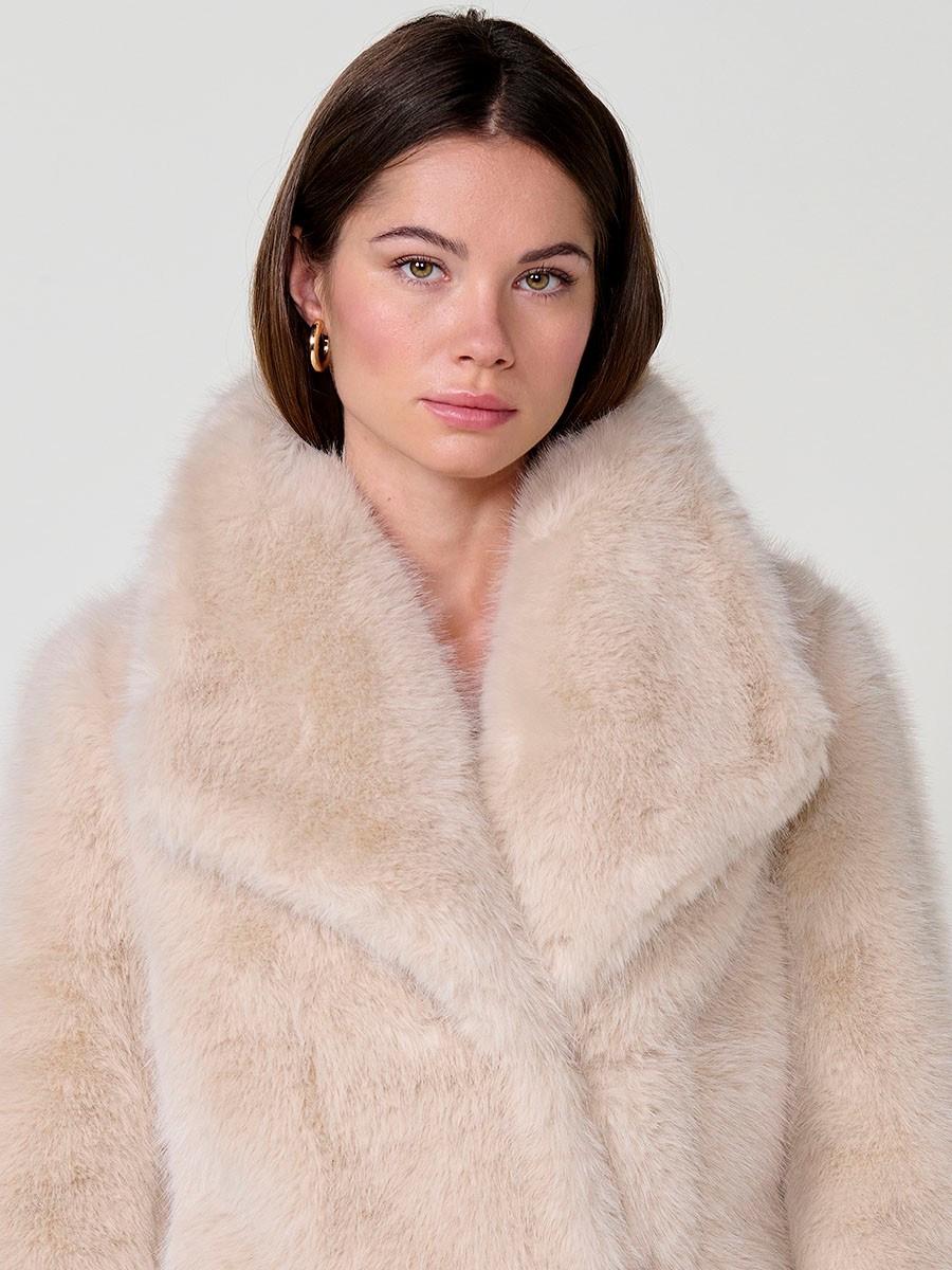 Chaqueta de mujer efecto pelo en color crudo, cuello solapa, bolsillos laterales y cierre frontal con botones ocultos.