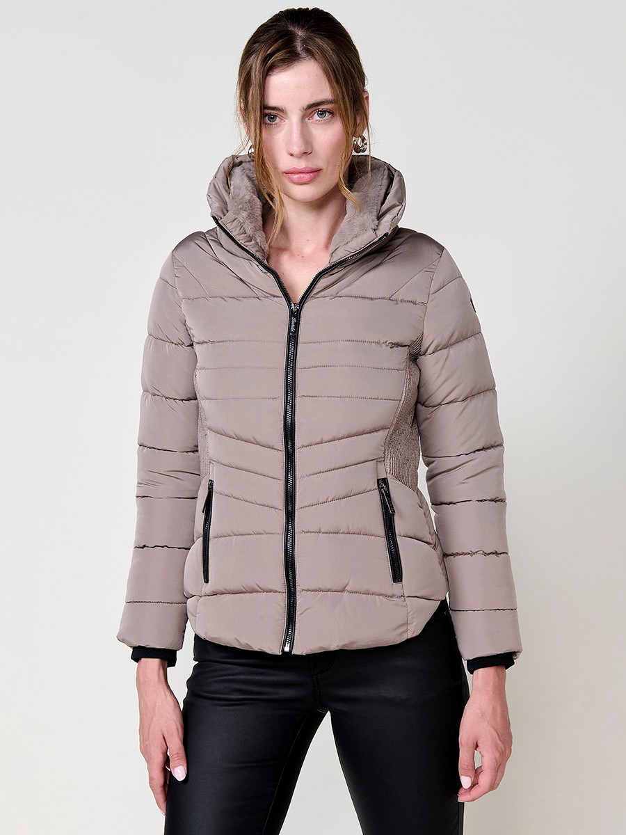 Chaqueta acolchada de mujer en color beige, cuello alto con forro efecto pelo, bolsillos laterales con cremallera y pespuntes canalé en los laterales.