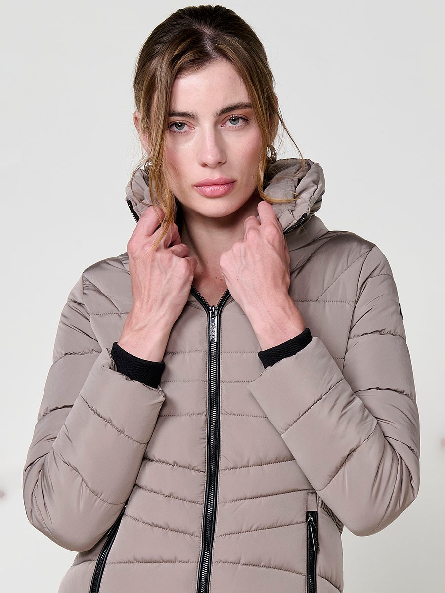 Chaqueta acolchada de mujer en color beige, cuello alto con forro efecto pelo, bolsillos laterales con cremallera y pespuntes canalé en los laterales.