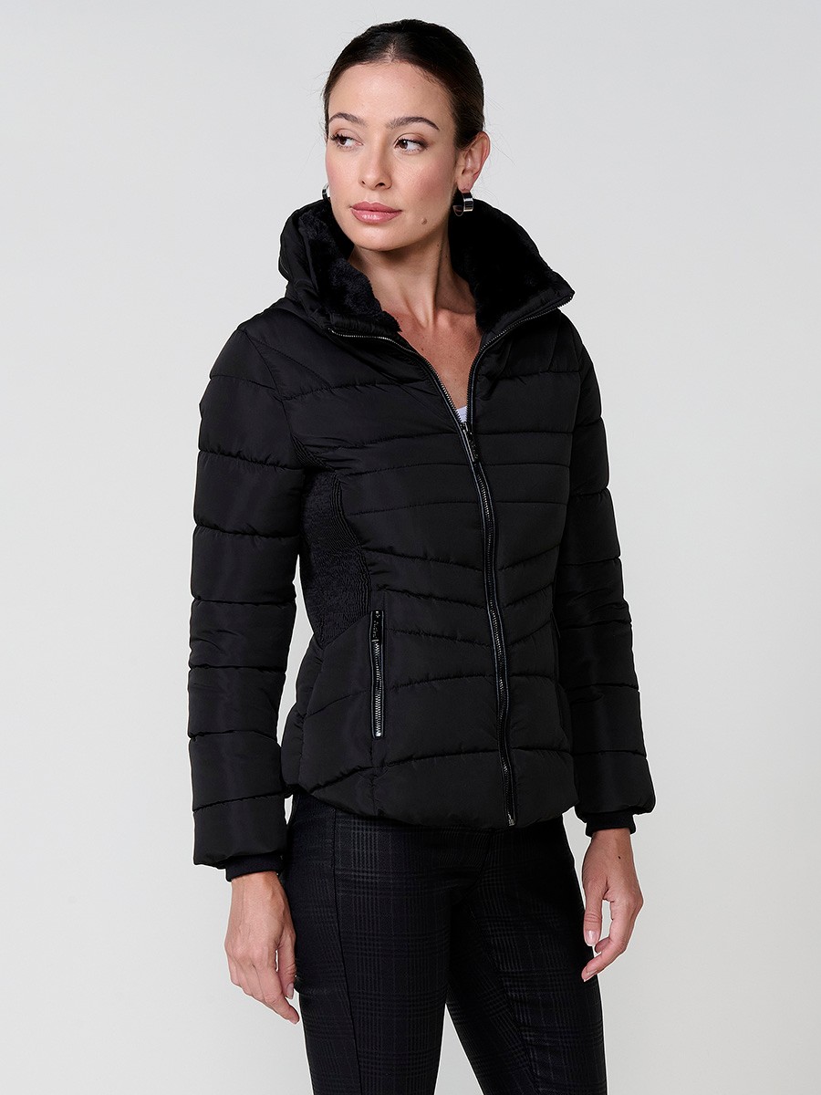 Chaqueta acolchada de mujer en color negro, cuello alto con forro efecto pelo, bolsillos laterales con cremallera y pespuntes canalé en los laterales.