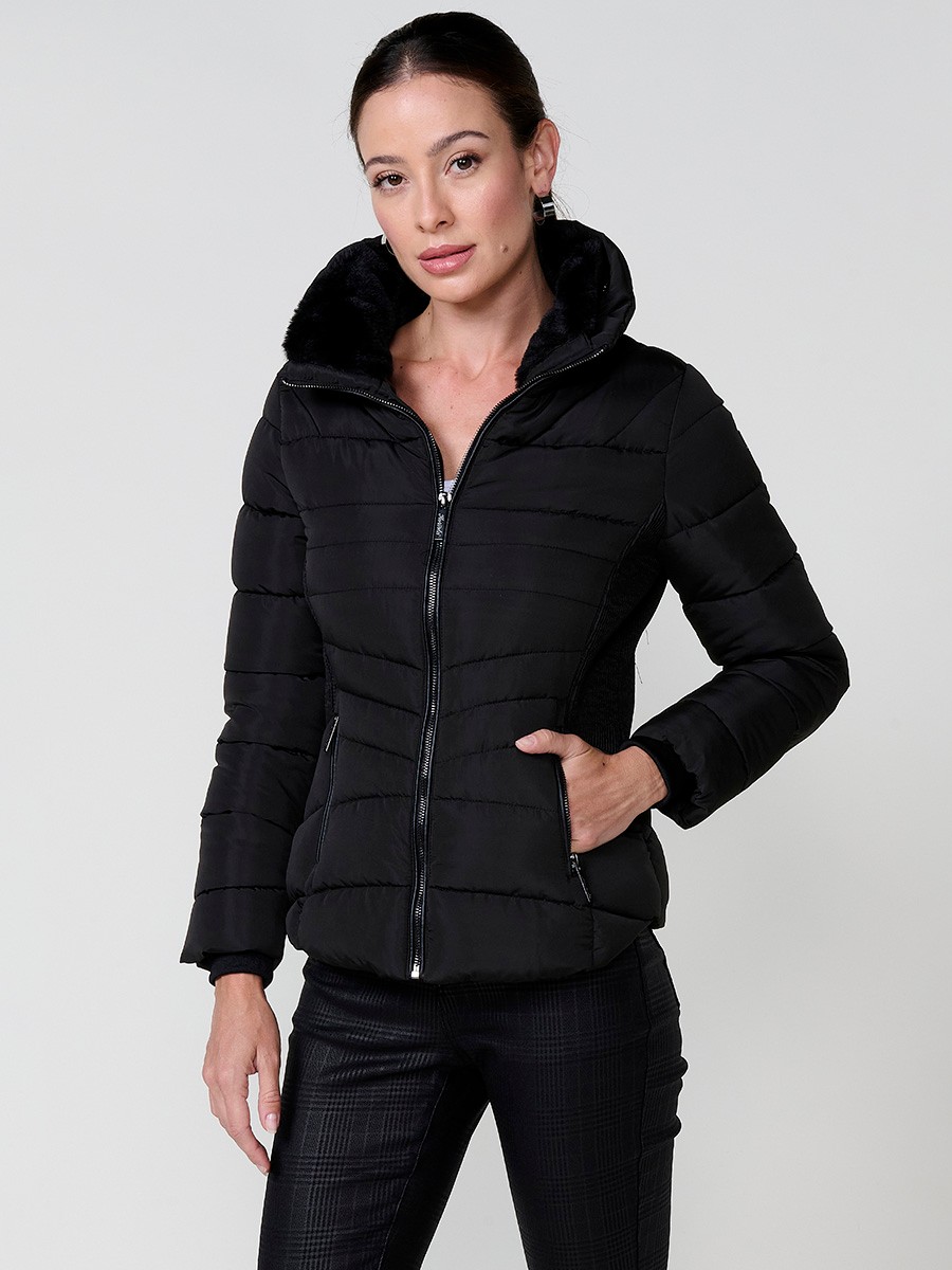 Chaqueta acolchada de mujer en color negro, cuello alto con forro efecto pelo, bolsillos laterales con cremallera y pespuntes canalé en los laterales.