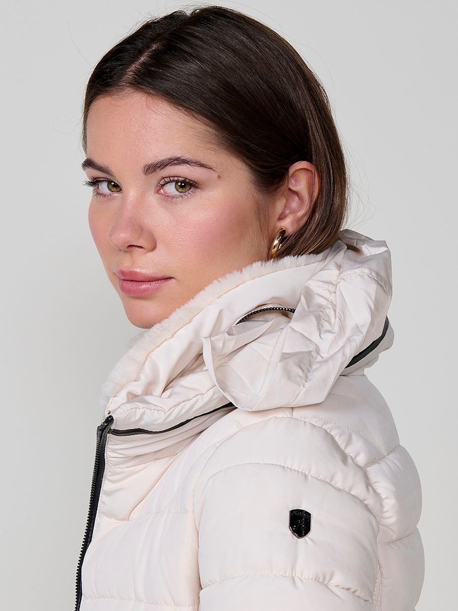 Chaqueta acolchada de mujer en color crudo, cuello alto con forro efecto pelo, bolsillos laterales con cremallera y detalle de pespuntes canalé.