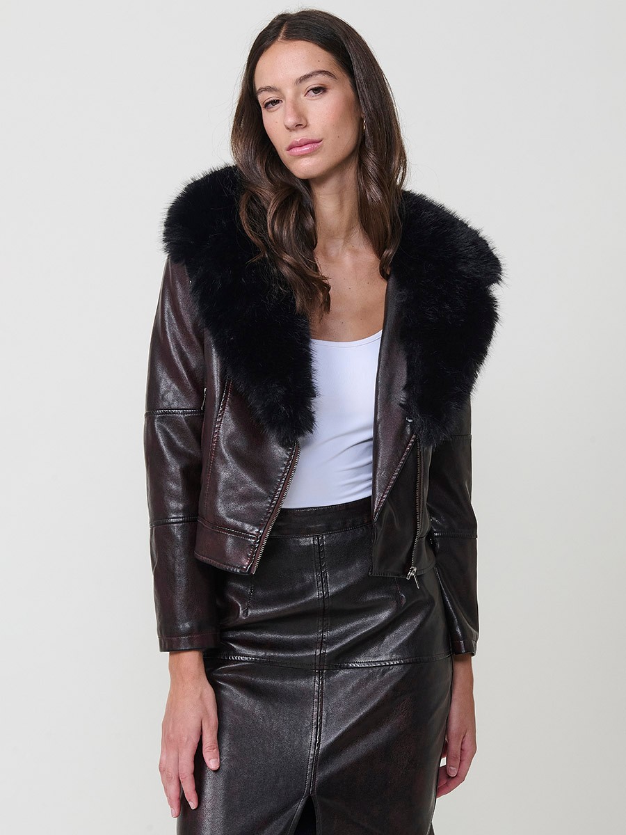 Women’s biker jacket in burgundy faux leather with faux fur lining, quilted sleeves, removable collar and zipper pockets.