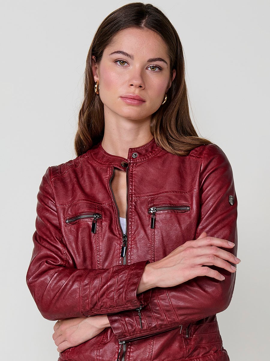 Women’s biker jacket in burgundy faux leather, mao collar, faux fur lining, quilted sleeves and metallic zippers.