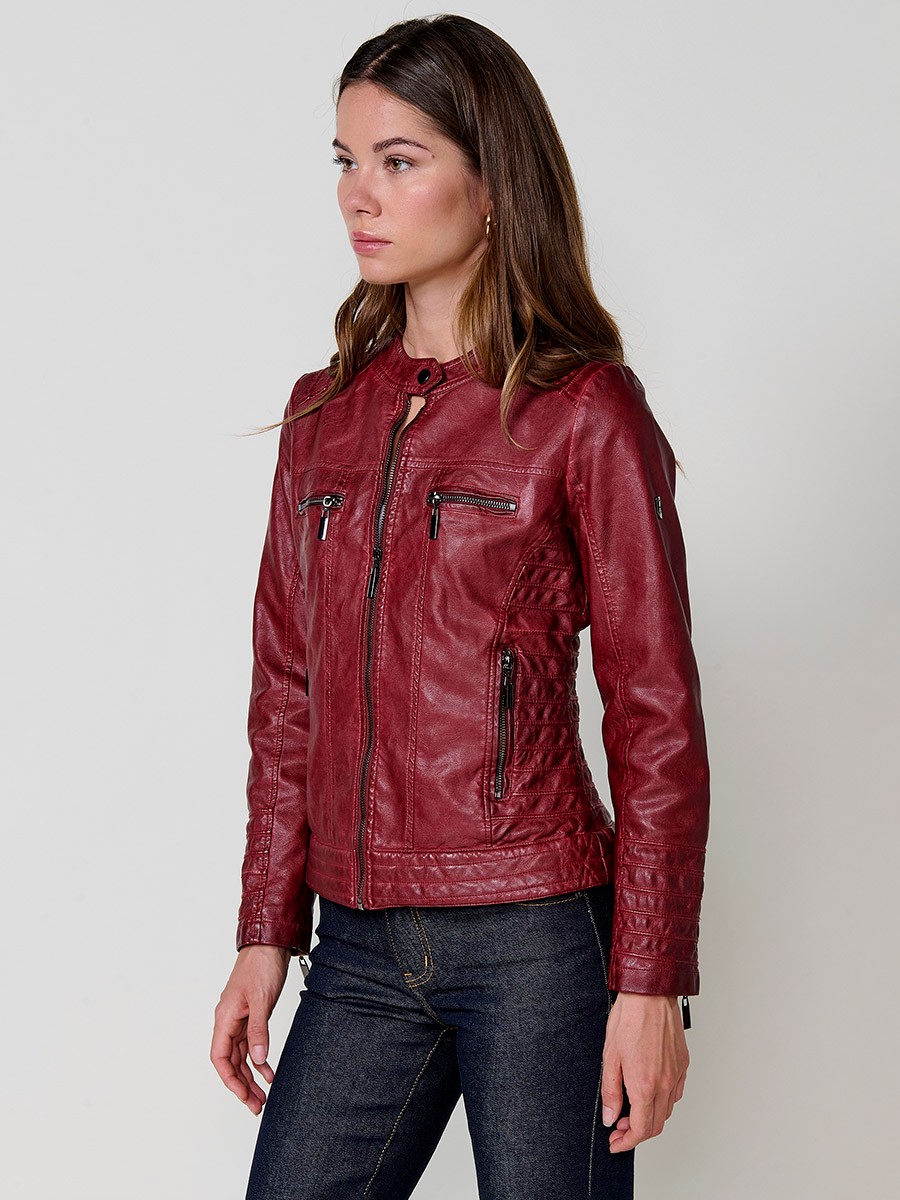 Women’s biker jacket in burgundy faux leather, mao collar, faux fur lining, quilted sleeves and metallic zippers.