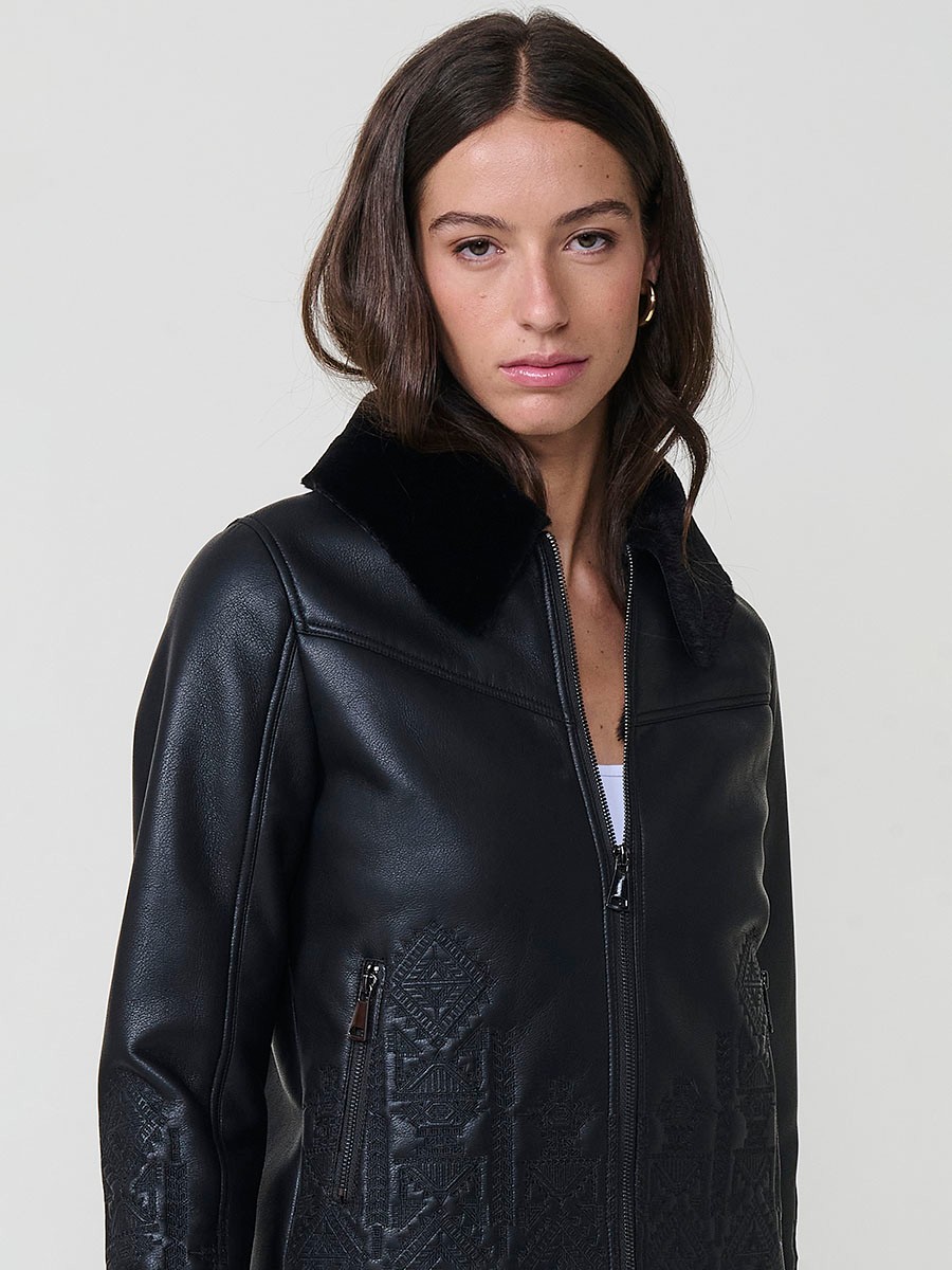 Women’s reversible jacket with faux leather exterior, faux fur lining, ethnic embroidery and metallic zippers.