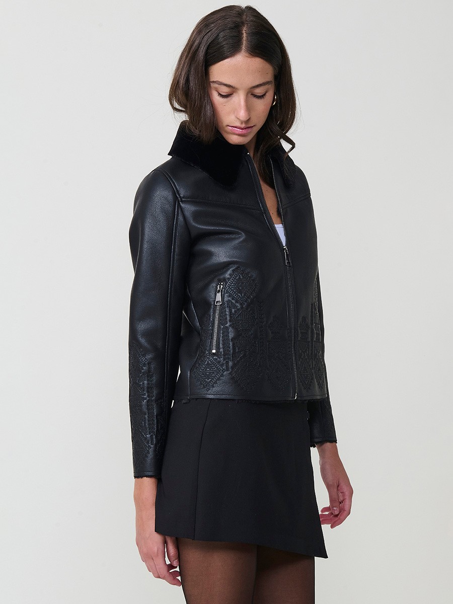 Women’s reversible jacket with faux leather exterior, faux fur lining, ethnic embroidery and metallic zippers.