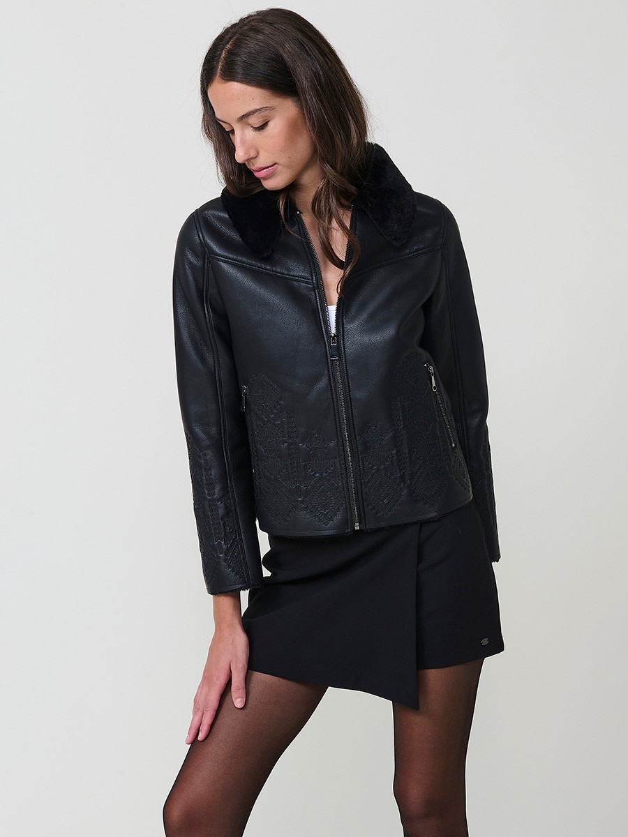 Women’s reversible jacket with faux leather exterior, faux fur lining, ethnic embroidery and metallic zippers.