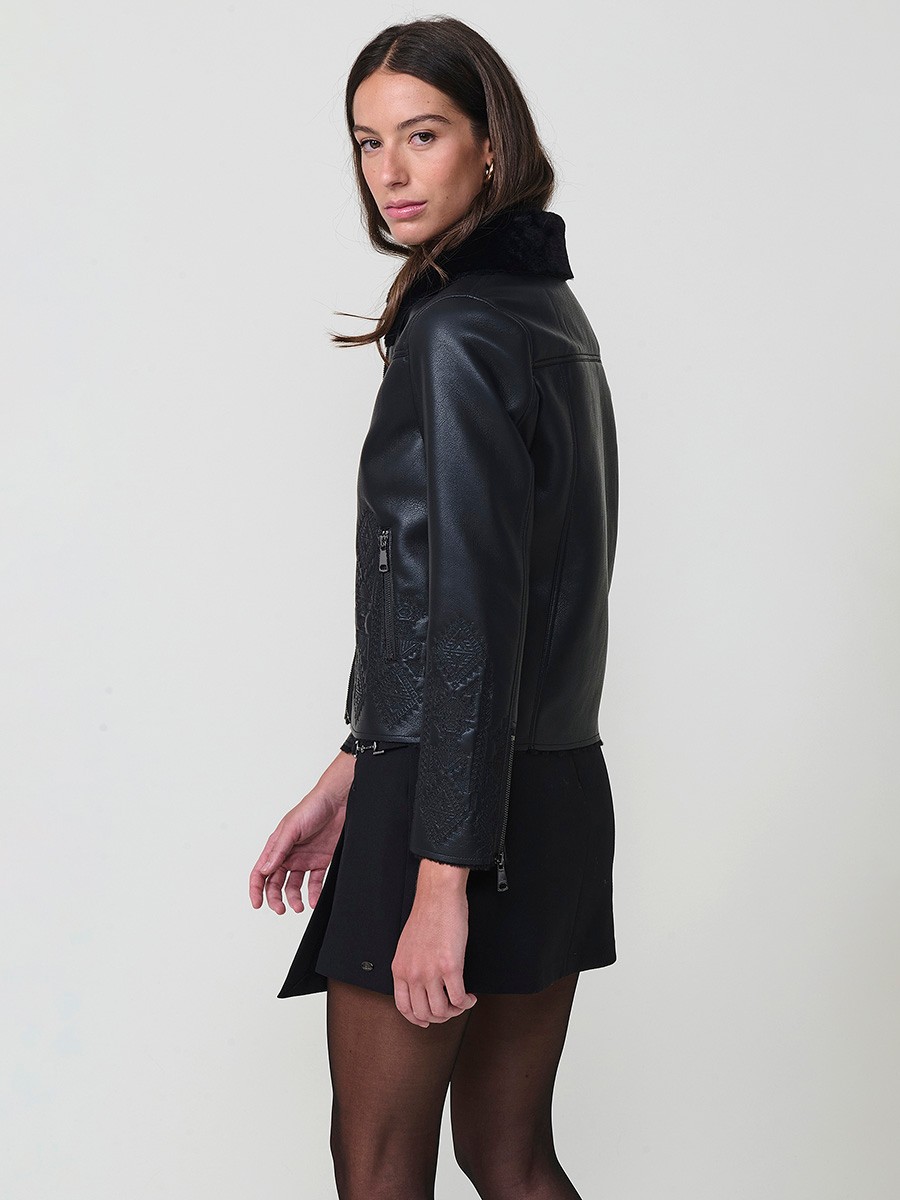 Women’s reversible jacket with faux leather exterior, faux fur lining, ethnic embroidery and metallic zippers.