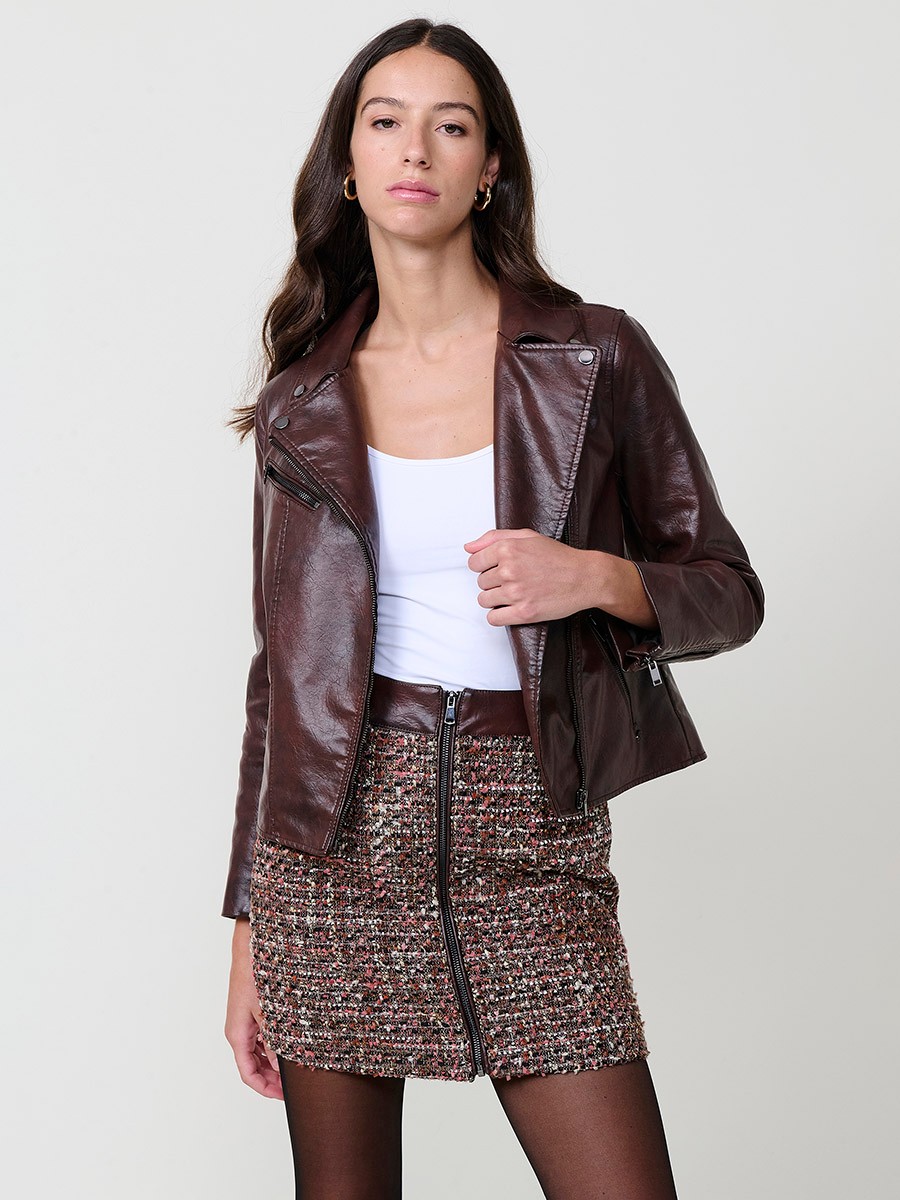 Women’s biker jacket in brown faux leather with quilted lining, metallic zipper pockets and stitched details.