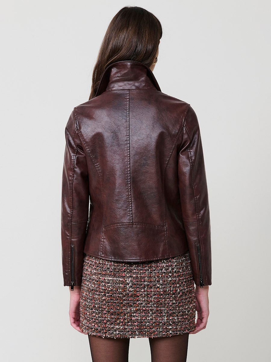 Women’s biker jacket in brown faux leather with quilted lining, metallic zipper pockets and stitched details.