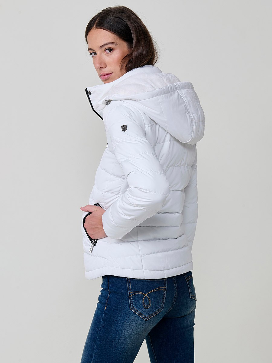 Chaqueta acolchada de mujer en color blanco, con cuello alto, capucha extraíble y forro efecto pelo. Diseño versátil y cálido para un estilo urbano moderno.