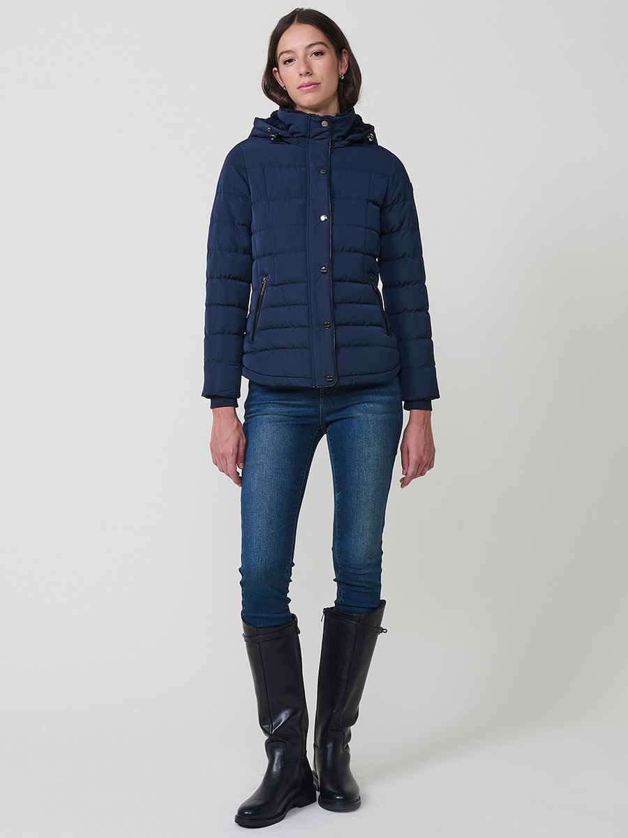 Chaqueta acolchada de mujer en color navy con cuello alto, capucha extraíble y forro efecto pelo. Prenda cálida y funcional con un estilo urbano y moderno.