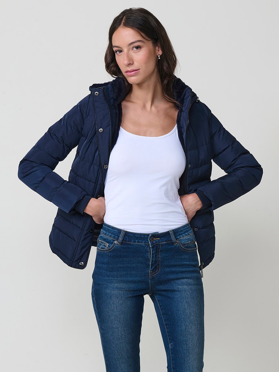 Chaqueta acolchada de mujer en color navy con cuello alto, capucha extraíble y forro efecto pelo. Prenda cálida y funcional con un estilo urbano y moderno.