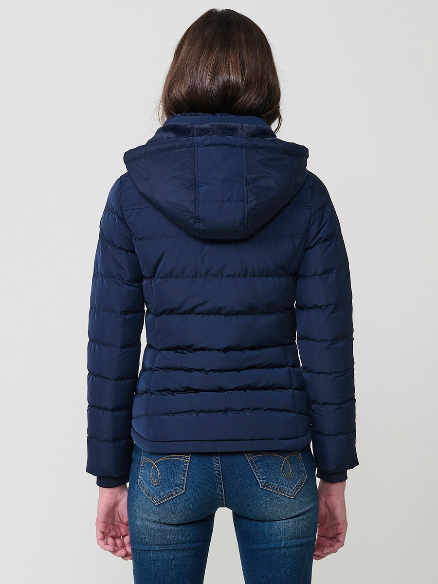 Chaqueta acolchada de mujer en color navy con cuello alto, capucha extraíble y forro efecto pelo. Prenda cálida y funcional con un estilo urbano y moderno.