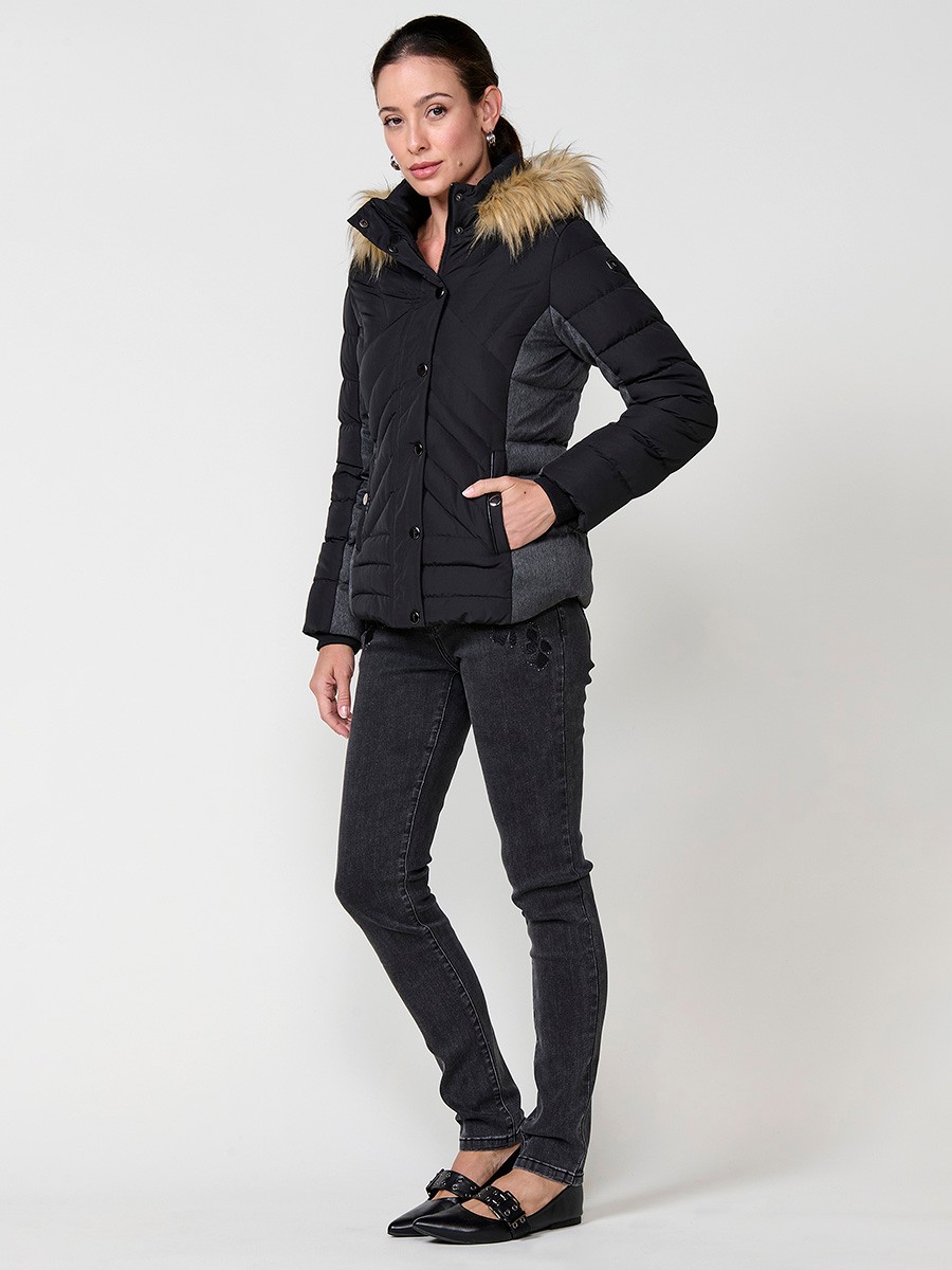 Chaqueta de mujer acolchada en color negro, cuello alto, capucha extraíble, detalles de efecto pelo y contrastes en laterales y mangas.