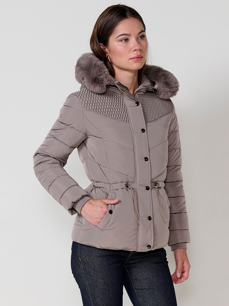 Chaqueta acolchada de mujer en color beige, cuello alto, capucha extraíble con cremallera y detalles de pelo desmontables. Forro liso al tono y puños de canalé.