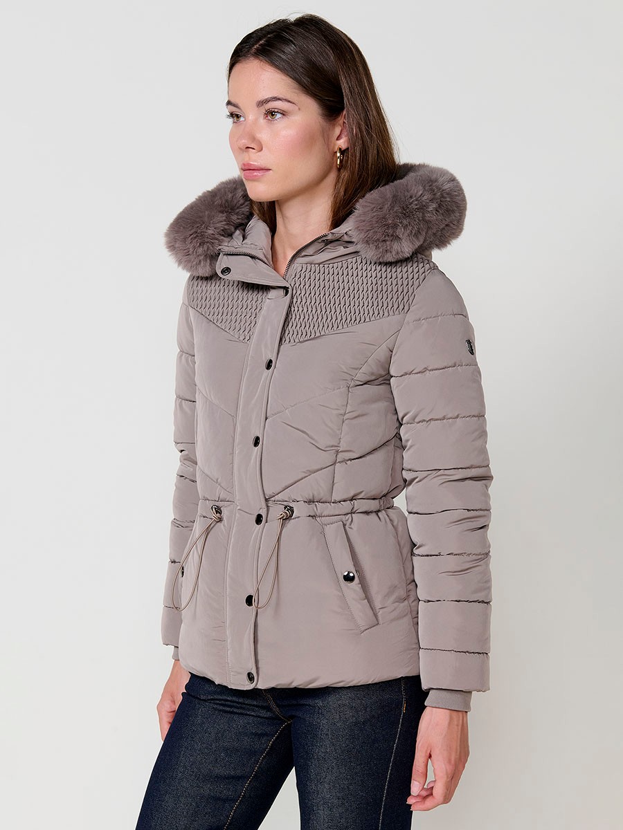 Chaqueta acolchada de mujer en color beige, cuello alto, capucha extraíble con cremallera y detalles de pelo desmontables. Forro liso al tono y puños de canalé.
