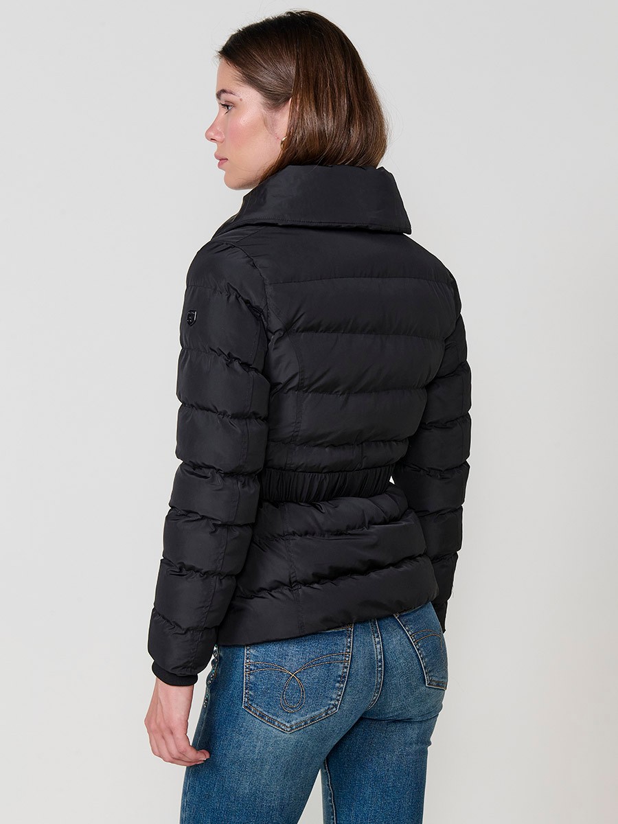Chaqueta de mujer acolchada en color negro, con doble cuello, forro al tono y cinturón elástico con hebilla.