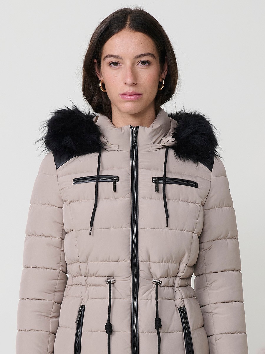 Chaqueta larga acolchada de mujer en color beige, con capucha de pelo y cierre delantero con cremallera.