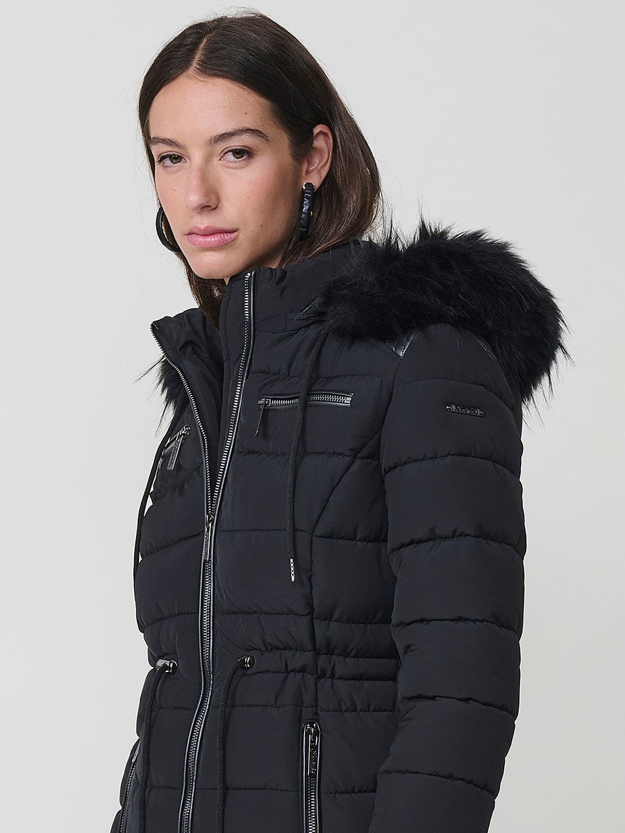 Chaqueta larga acolchada de mujer en color negro, con capucha de pelo y cierre delantero con cremallera.