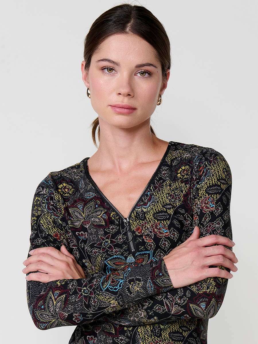 Women’s long sleeve floral top with V-neckline and metallic zipper with ring detail. Koröshi logo plate on the front.