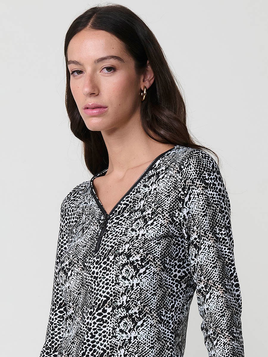 Women’s long sleeve animal print top with V-neckline, metallic ring zipper, and Koröshi logo plate.