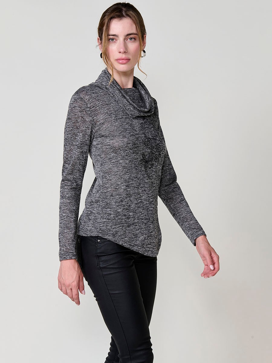 Women’s long sleeve turtleneck top in flamé melange fabric with asymmetric hem, diagonal buttons and shiny embroidery.