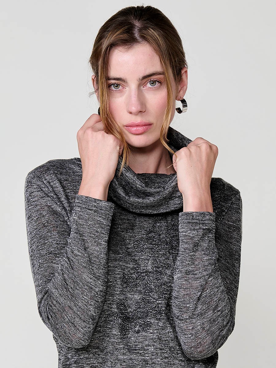 Women’s long sleeve turtleneck top in flamé melange fabric with asymmetric hem, diagonal buttons and shiny embroidery.