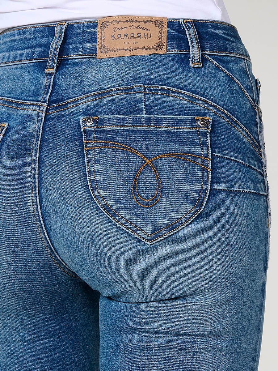 Pantalón jeans regular doble push up azul oscuro de tiro medio, con cinco bolsillos, cierre metálico y bordado con brillos.