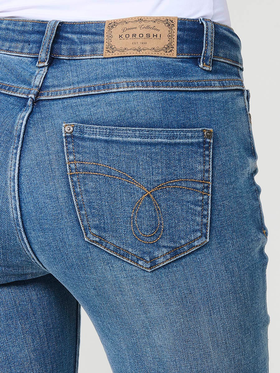 Dunkelblaue Damen-Bootcut-Jeans aus Stretch-Denim, mittlere Leibhöhe, fünf Taschen, ausgefranste Säume und Stickerei.