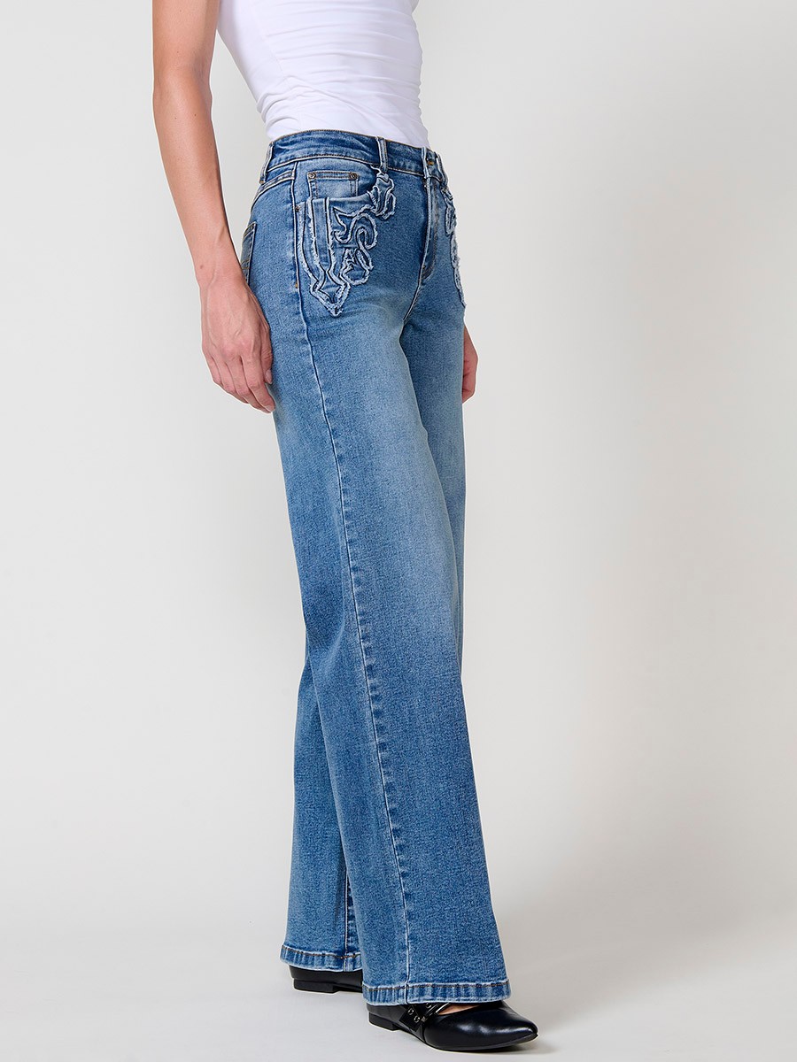 Jeans wide azul oscuro elásticos de tiro medio, cinco bolsillos, cierre metálico y patch bordado en bolsillos delanteros.