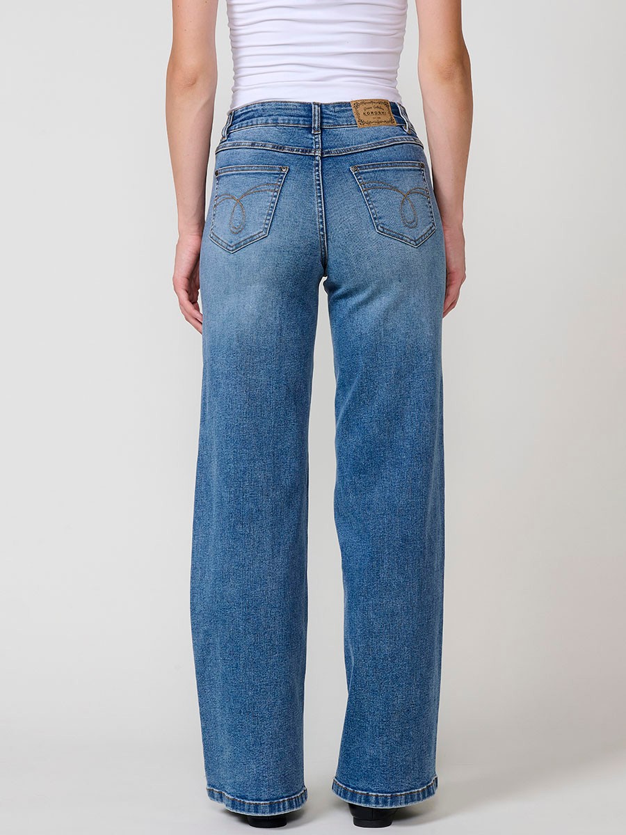 Jeans wide azul oscuro elásticos de tiro medio, cinco bolsillos, cierre metálico y patch bordado en bolsillos delanteros.