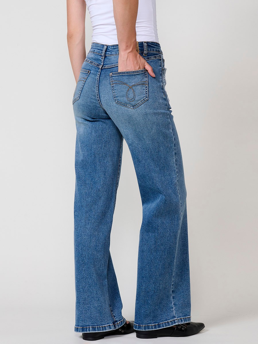 Jeans wide azul oscuro elásticos de tiro medio, cinco bolsillos, cierre metálico y patch bordado en bolsillos delanteros.