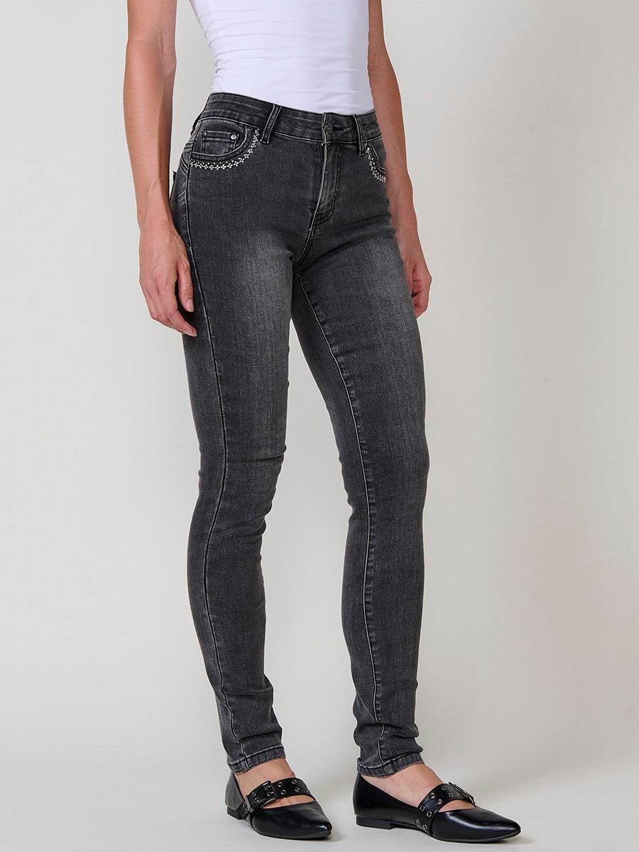 Jeans slim push up de mujer en denim negro elástico, con cinco bolsillos, cierre metálico y bordado frontal con brillos.