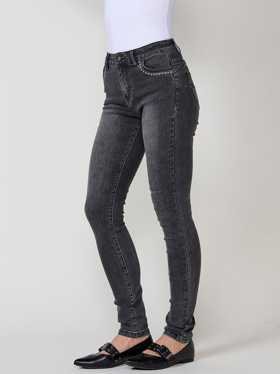 Jeans slim push up de mujer en denim negro elástico, con cinco bolsillos, cierre metálico y bordado frontal con brillos.