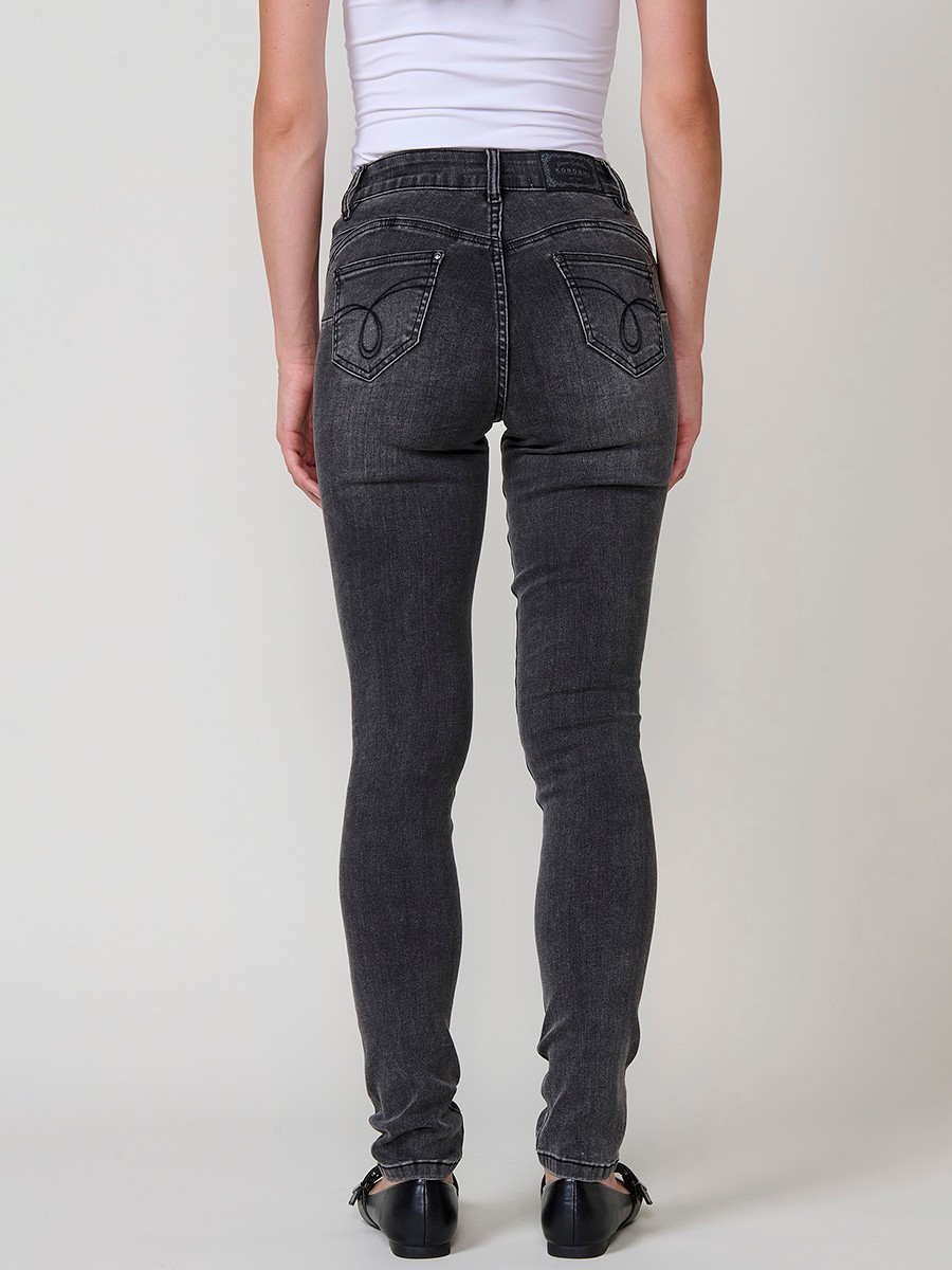 Jeans slim push up de mujer en denim negro elástico, con cinco bolsillos, cierre metálico y bordado frontal con brillos.