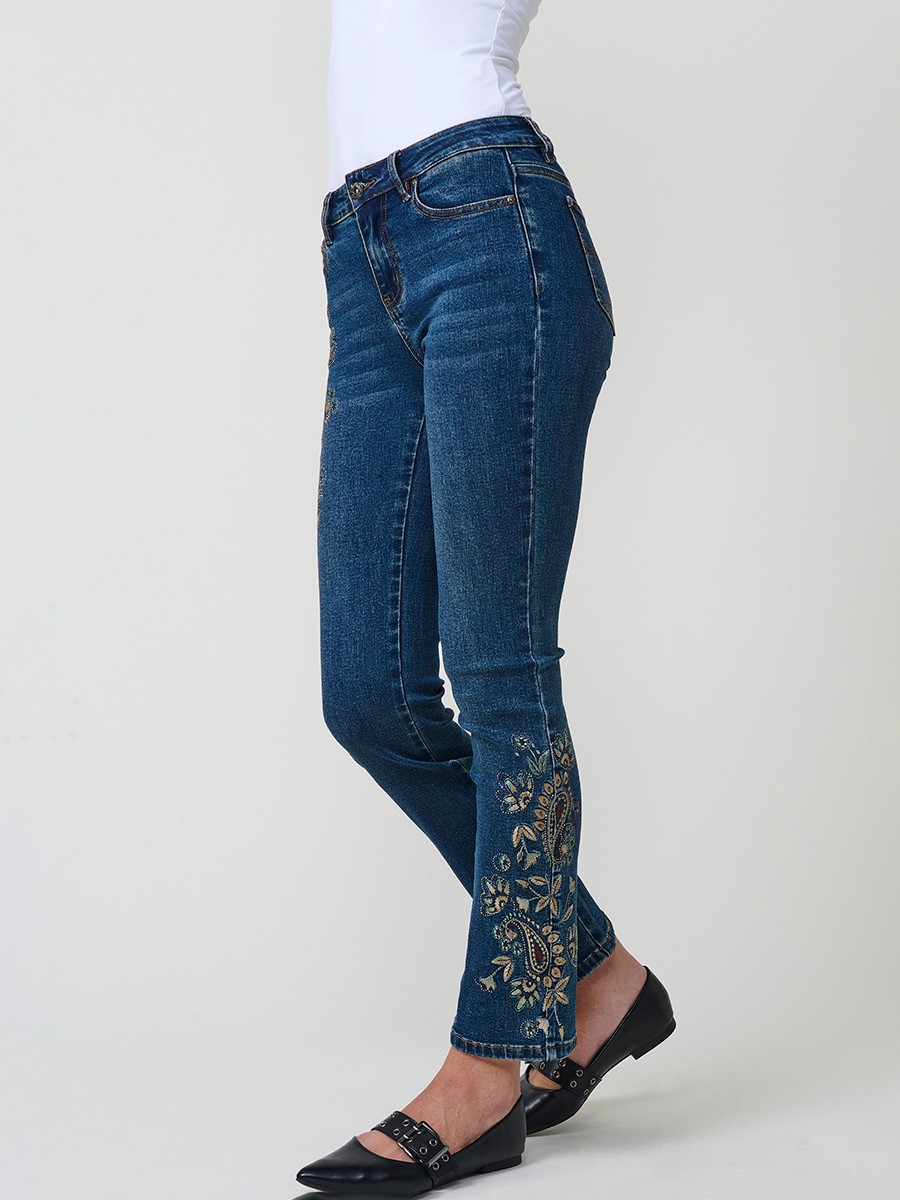 Jeans slim azul muy oscuro elásticos, tiro medio, cinco bolsillos, cierre metálico y bordado con brillos en bolsillo y bajo.