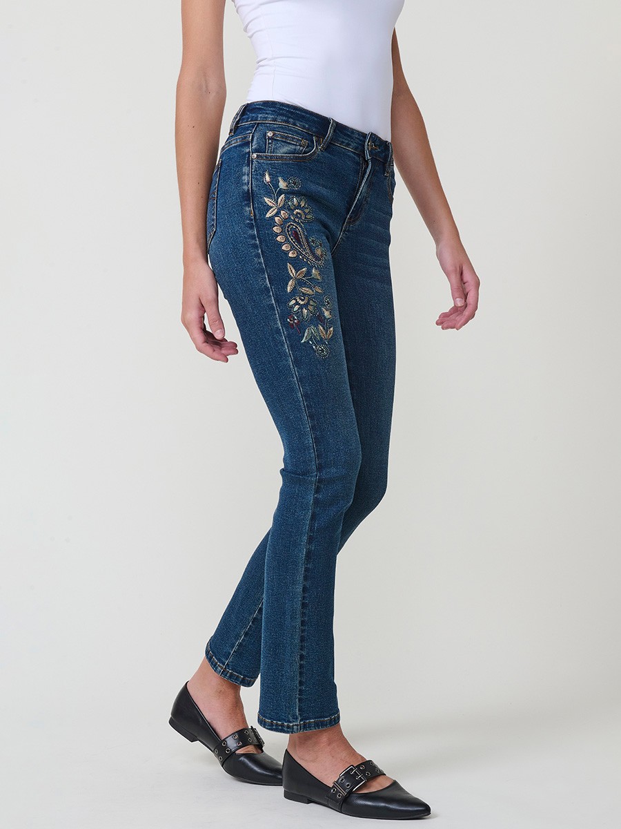 Jeans slim azul muy oscuro elásticos, tiro medio, cinco bolsillos, cierre metálico y bordado con brillos en bolsillo y bajo.
