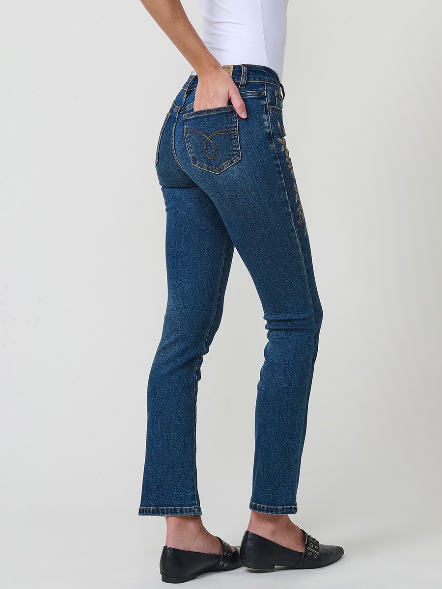Jeans slim azul muy oscuro elásticos, tiro medio, cinco bolsillos, cierre metálico y bordado con brillos en bolsillo y bajo.